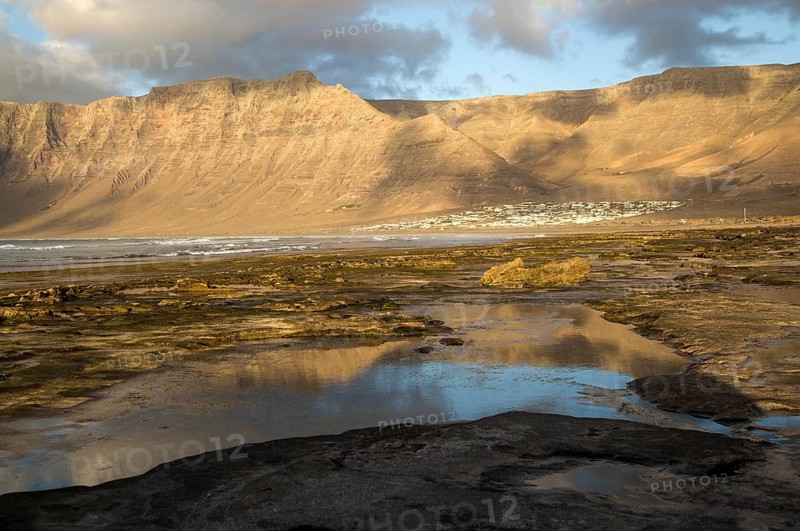 Late afternoon light on beach and cliffs La Caleta de Famara, Lanzarote, Canary islands, Spain, Europe