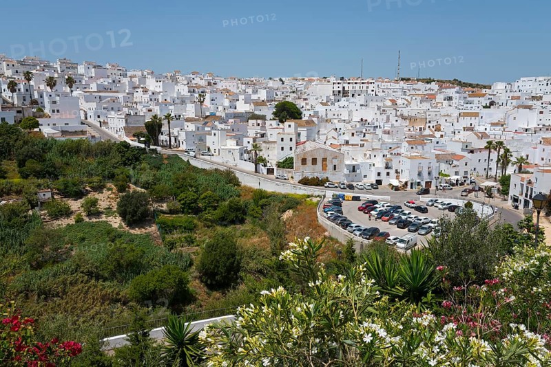 View over a hilly landscape with green vegetation and white houses in the background, New Town, Vejer de la Frontera, Cadiz province, Cadiz, Andalusia, Spain, Europe