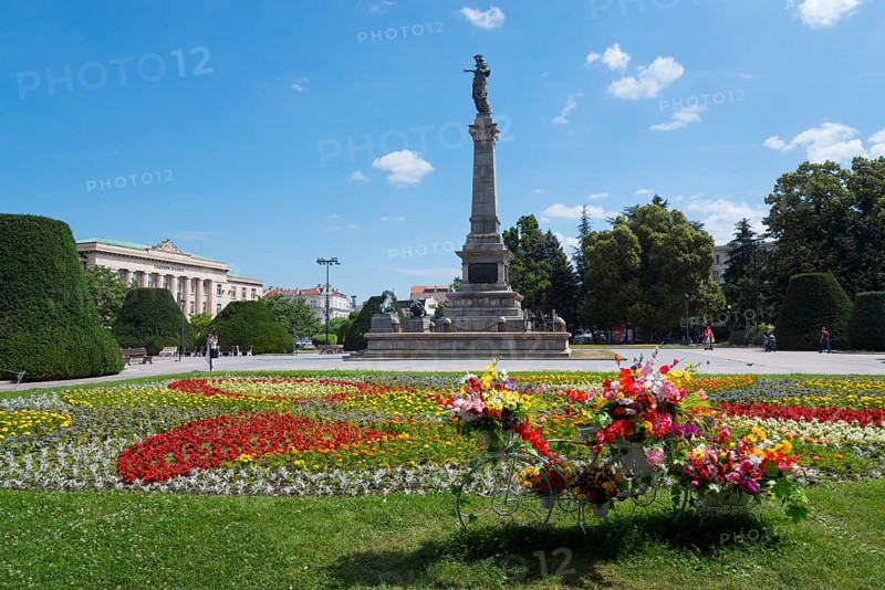 A sunny park with a large monument surrounded by colourful flowerbeds and green trees, Municipal Courthouse, Monument to Freedom, Russe, Rousse, Ruse, Pyce, Bulgaria, Europe