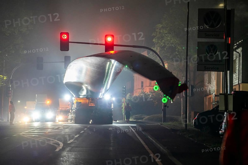 Transport of a 68 metre long, 22 tonne blade of a wind turbine, here in Breckerfeld, with a self-propelled Blade-Lifter vehicle, over a 40 km long route, over 2 nights, in the Bergisches Land, through towns, villages, over country roads, narrow through roads, to the construction site of the wind turbine near Hagen, North Rhine-Westphalia, Germany, Europe