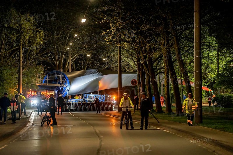 Transport of a 68 metre long, 22 tonne blade of a wind turbine, here in Schwelm, onlookers, with a self-propelled Blade-Lifter vehicle, over a 40 km long route, over 2 nights, in the Bergisches Land, through towns, villages, over country roads, narrow through roads, to the construction site of the wind turbine near Hagen, North Rhine-Westphalia, Germany, Europe