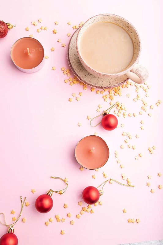 Christmas or New Year composition. Decorations, red balls, cup of coffee, on a pink paper background. Top view, copy space, flat lay