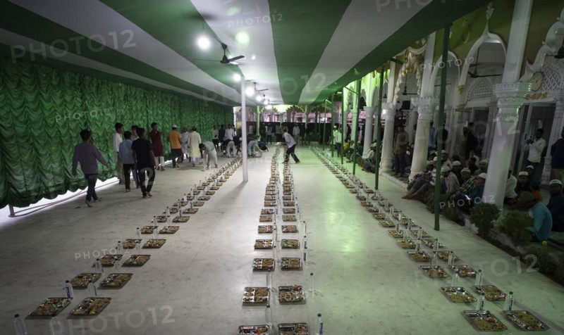 Volunteers distribute and arrange rows of 'iftar' meal for devotees to break their fast, during the holy month of Ramadan, at Burha Jame Masjid, on March 13, 2024 in Guwahati, Assam, India, Asia