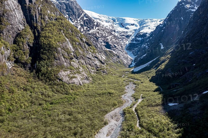 Aerial view of valley and gravel mountain road to glacier Kjenndalsbreen, valley Lodalen south of village Loen, Norway, Europe