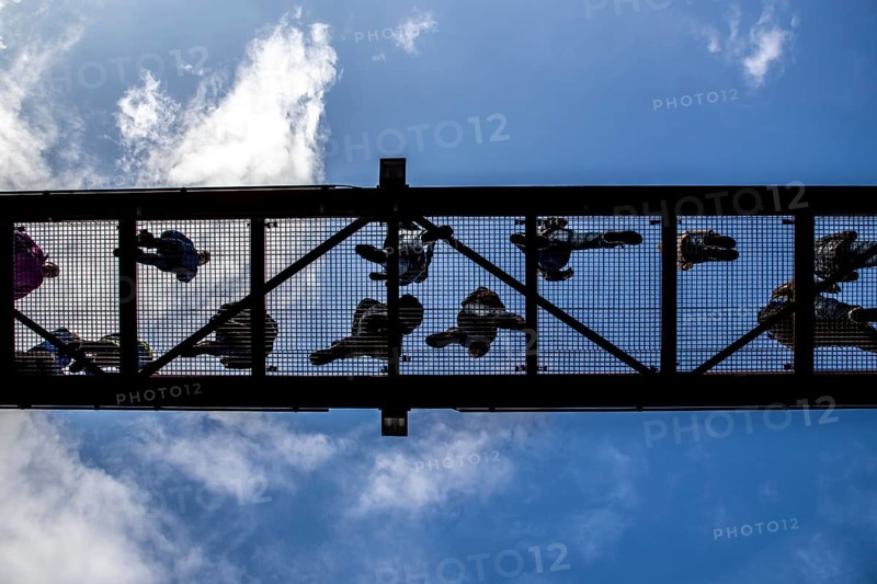 Lattice walkway, people walk over a walkway at a height of a good 15 metres, made of steel lattice, seen from below, viewing platform