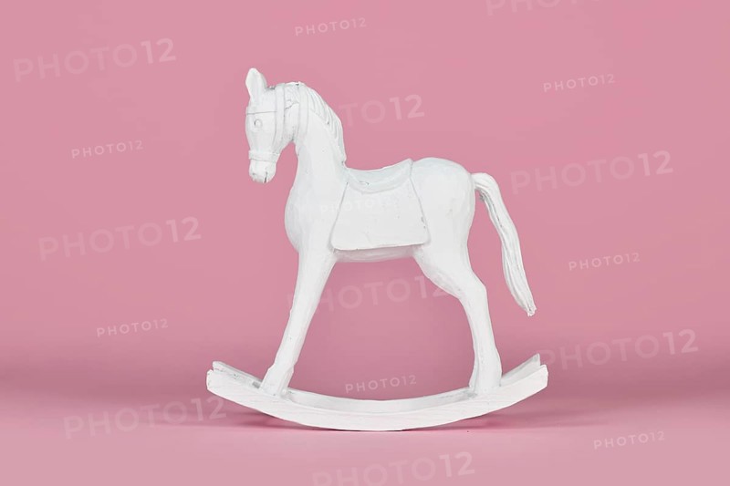 White wooden retro style rocking horse Christmas home decor object on pink background