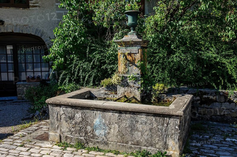 Old historic fountain with curved tap Water spout for permanent drinking water supply Clean drinkable water for human consumption Food with sign Eau potable, above goblet Cup vase for without flowers, Les Planches-prés-Arbois, Bourgogne-Franche-Comté, Département Jura, France, Europe