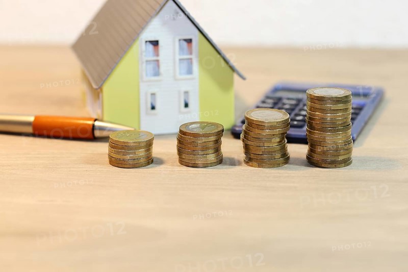 Concept photo with model house and coins
