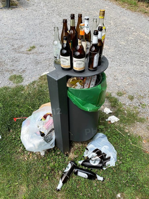 Overflowing rubbish bin, with lots of rubbish, glass bottles next to it, party rubbish, at a viewpoint in the forest, Korte Klippe, Essen, North Rhine-Westphalia, Germany, Europe