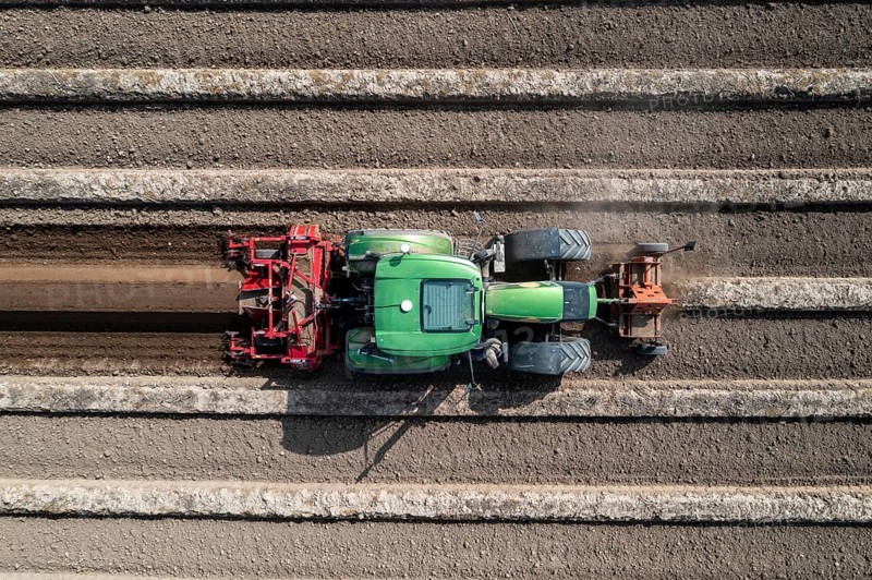 A farmer builds asparagus ridges on a field with the help of an asparagus tiller, in which the asparagus then grows, Dormagen, North Rhine-Westphalia, Germany, Europe