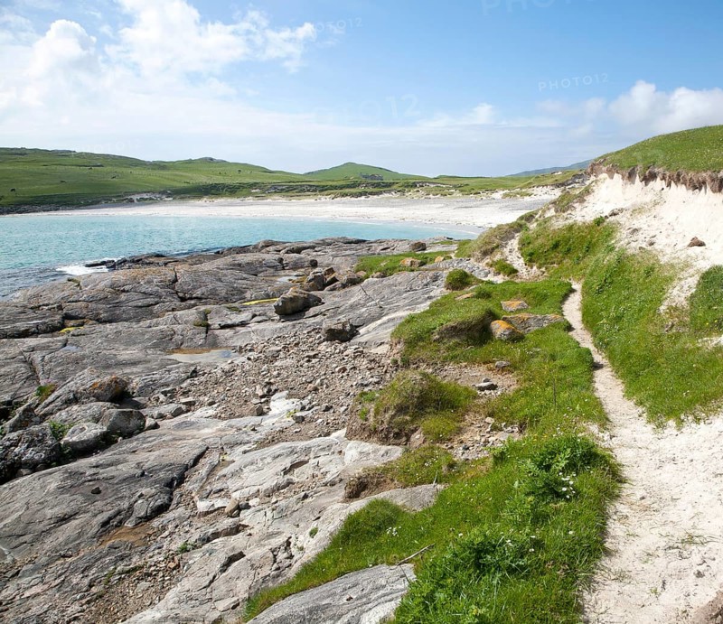 Rocky headland and sandy beach at Bagh a Deas, South Bay, Vatersay island, Barra, Outer Hebrides, Scotland, UK