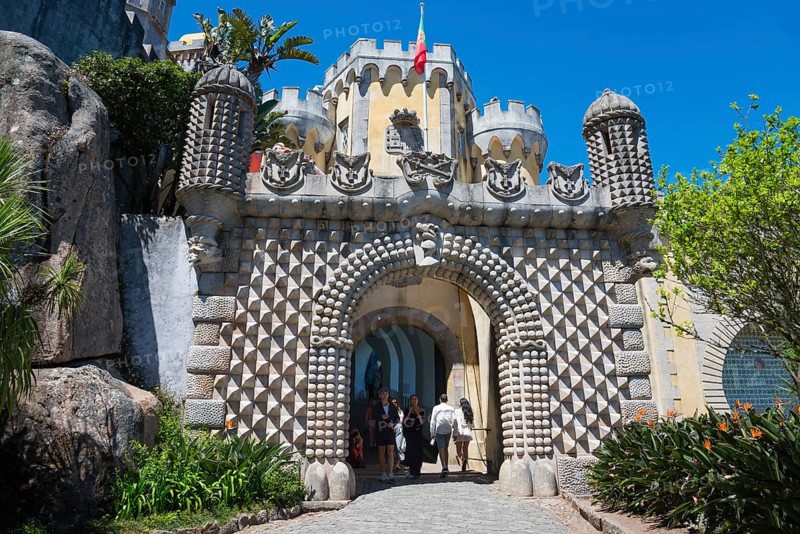 Entrance gate of a castle with decorative stone patterns and plants, visitors are visible, Palácio Nacional da Pena, National Palace Pena, Sintra, Lisbon, World Heritage Site, UNESCO, Portugal, Europe