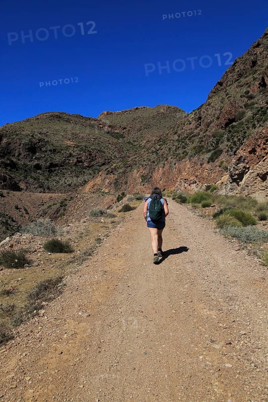 Woman walking along coast path in Cabo de Gata national park, near San José, Almeria, Spain, Europe