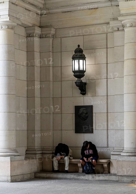 Young people sitting under a candelabra at the entrance to the State Library, Berlin, Germany, Europe