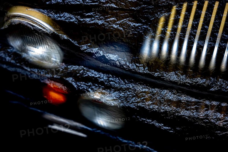 Car Lamps and Car Grille on the Front of a an Old Classic Car Covered with Plastic Protection in Switzerland