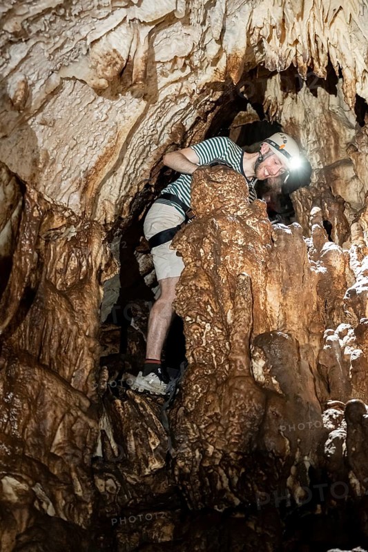 Young man with helmet and headlamp, tourist between stalactites and stalagmites in a stalactite cave, Terciopelo Cave, Barra Honda National Park, Costa Rica, Central America