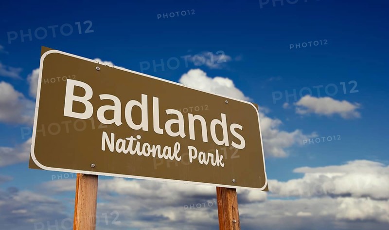 Badlands national park (south dakota) road sign against blue sky and clouds