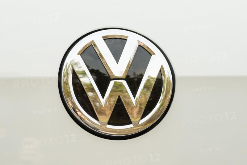 Shiny, silver Volkswagen logo, emblem with black interior on white background, golden reflection, Lower Saxony, Germany, Europe