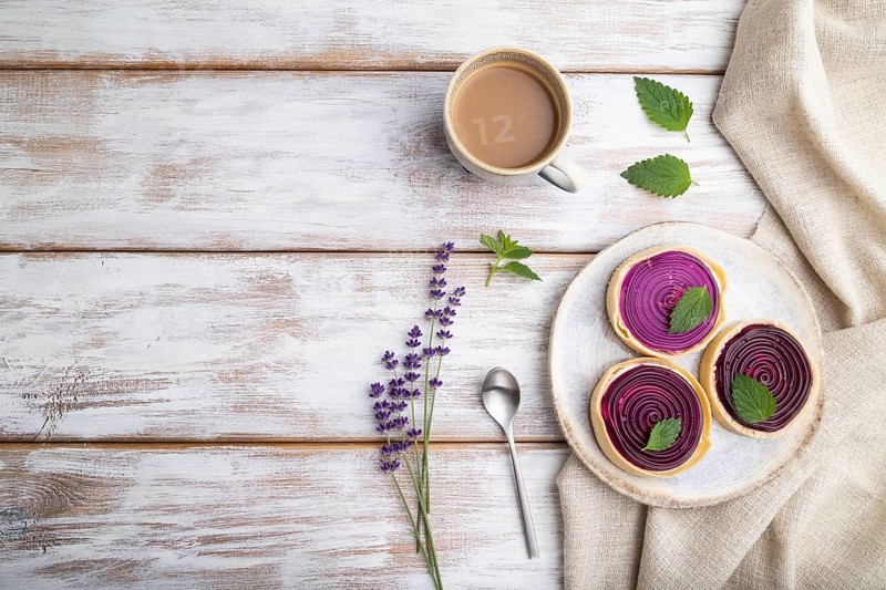 Sweet tartlets with jelly and milk cream with cup of coffee on a white wooden background and linen textile. top view, flat lay, copy space