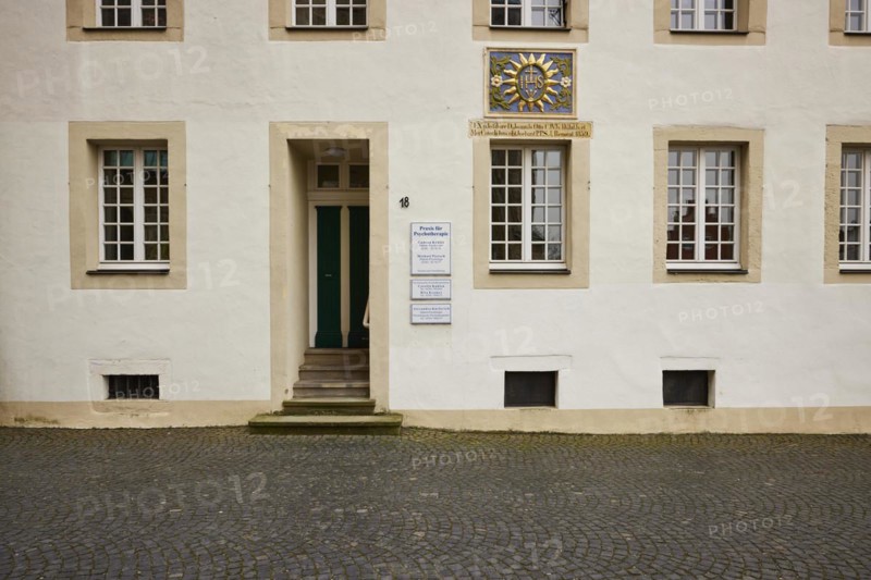 Façade of a historic building with white windows and a colourful family coat of arms in the old town of Warendorf, Warendorf district, North Rhine-Westphalia, Germany, Europe