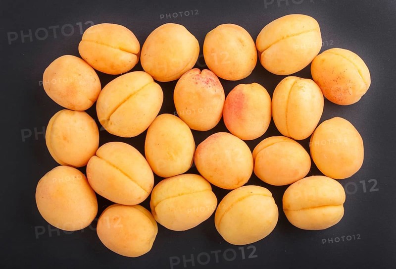 Apricots on black background, top view, flat lay