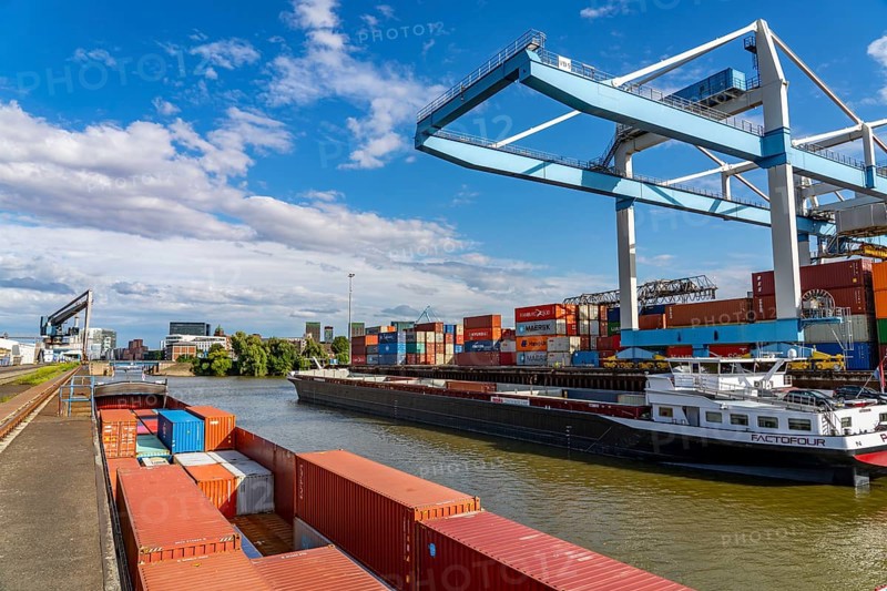 New customs yard building complex, the Gehry buildings, at the media harbour, behind it the city gate building, harbour facilities, container ship at the terminal of DCH Düsseldorfer Container Hafen GmbH Düsseldorf, North Rhine-Westphalia, Germany, Europe
