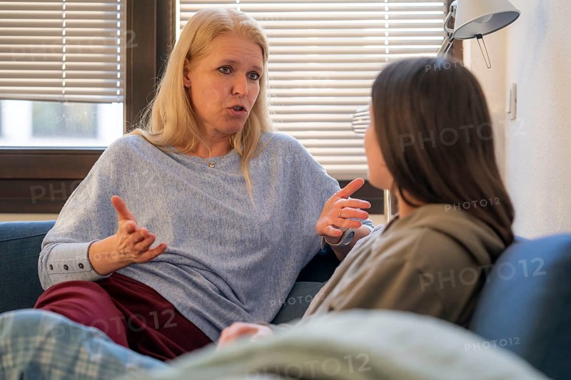 Mother and daughter, teenage, 13 years old, in a confidential conversation, at home