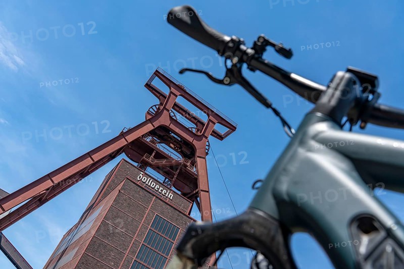 Cycling in the Ruhr region, by bike, e-bike, at the Zollverein Coal Mine Industrial Complex World Heritage Site, double trestle winding tower shaft XII, Essen, North Rhine-Westphalia, Germany, Europe