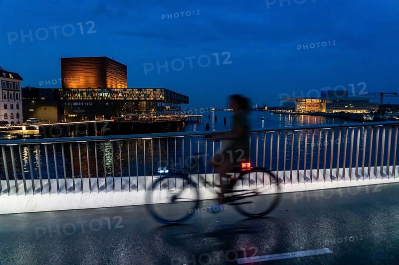 Cyclists on the Inderhavnsbroen cycle and footpath bridge, across the harbour, at night, at Nyhavn, Copenhagen is considered the cycling capital of the world, 45 % of the population travel by bike, Denmark, Europe
