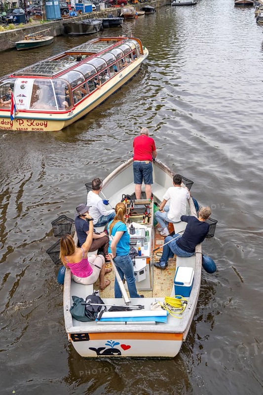 Plastic Whale boat in a canal in Amsterdam, passengers fish plastic waste out of the canals, tour through the canals of Amsterdam, collecting waste as an event, Netherlands