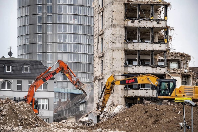 Demolition of the former RWE building complex, in the city centre, on the A40 motorway in Essen, excavator working on the piles of rubble, in the background the RWE Tower, North Rhine-Westphalia, Germany, Europe