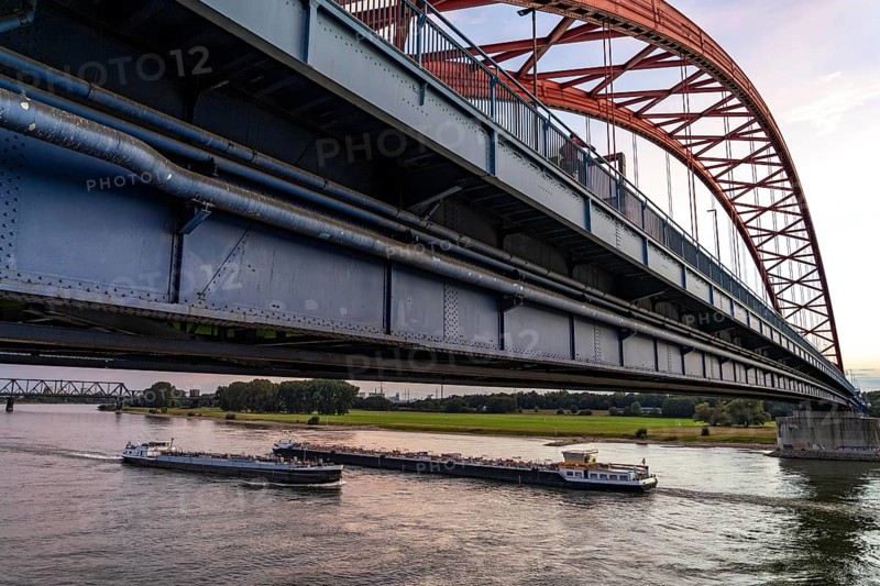 The Bridge of Solidarity, the longest tied-arch bridge in Germany, over the Rhine from Duisburg-Hochfeld to DU-Rheinhausen, the road bridge is dilapidated and has to be rebuilt, many thousands of lorries from the Logport port and cars use the bridge every day, new construction by 2040, cargo ships, behind the Duisburg-Hochfeld railway bridge, Duisburg, North Rhine-Westphalia, Germany, Europe