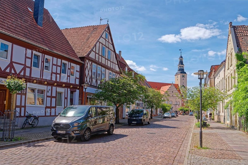 Residential and commercial buildings in Rudolf-Breitscheid-Straße, paved with cobblestones, in the old town centre of Gardelegen in the Altmark, with the town hall in the background. Hanseatic town of Gardelegen, Saxony-Anhalt, Germany, Europe