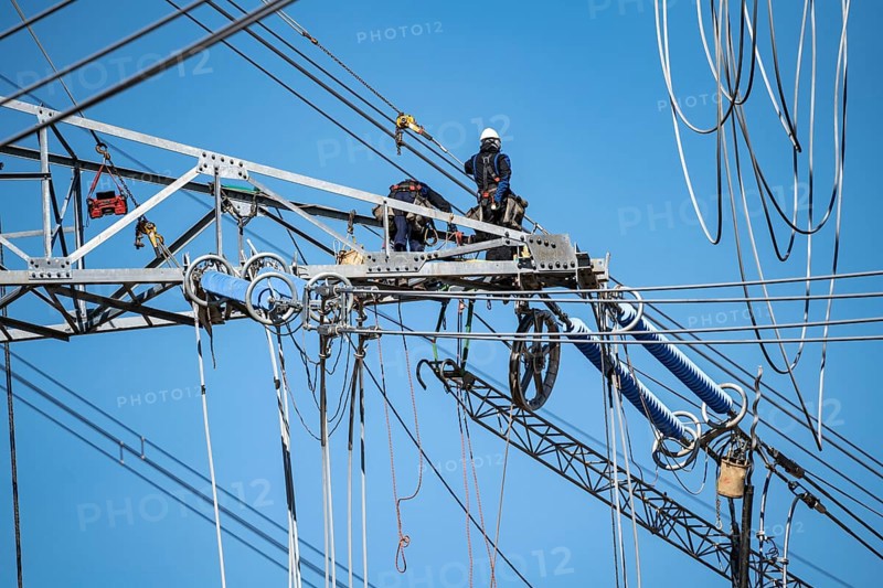 Construction of a new line route, 380 KV extra-high voltage line between Osterath and Gohr, near Neuss, fitter on a boom of an electricity pylon, at great height, North Rhine-Westphalia, Germany, Europe