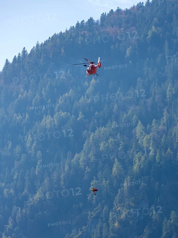 Injured person in a mountain bag with an air rescuer being winched into the rescue helicopter Christoph 14 with the cable winch, Bad Reichenhall, Berchtesgadener Land, Upper Bavaria, Bavaria, Germany, Europe