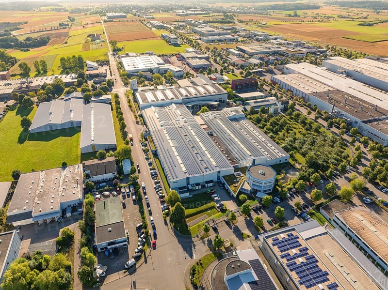 An industrial area with several buildings, green areas and solar modules, seen from a bird's eye view, Wolfsberg industrial area, Nagold, Black Forest, Germany, Europe