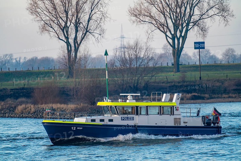 Boat of the water police, WSP 12, from Duisburg, patrol, behind cooling tower of the coal-fired power plant Duisburg-Walsum, operated by STEAG and EVN AG, 181 metres high, power plant unit 10, water vapour cloud, container cargo ship on the Rhine, Duisburg, North Rhine-Westphalia, Germany, Europe