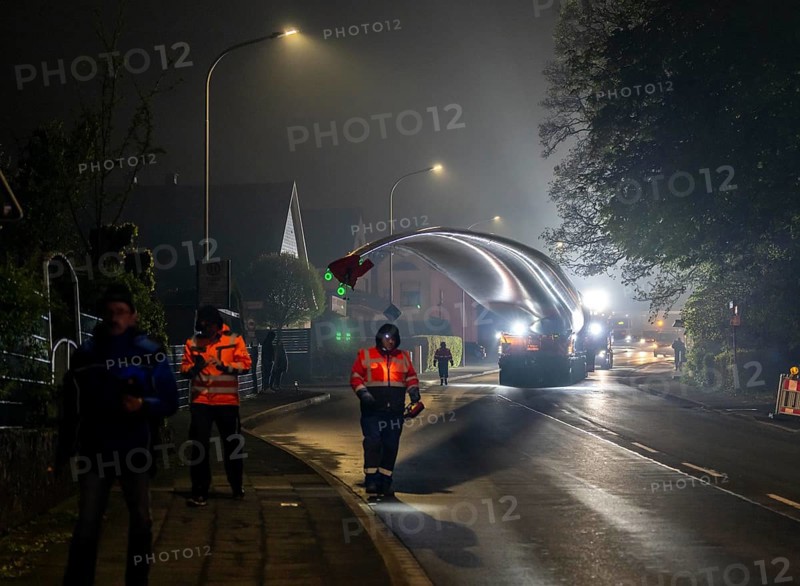 Transport of a 68 metre long, 22 tonne blade of a wind turbine, here in Breckerfeld, with a self-propelled Blade-Lifter vehicle, over a 40 km long route, over 2 nights, in the Bergisches Land, through towns, villages, over country roads, narrow through roads, to the construction site of the wind turbine near Hagen, North Rhine-Westphalia, Germany, Europe