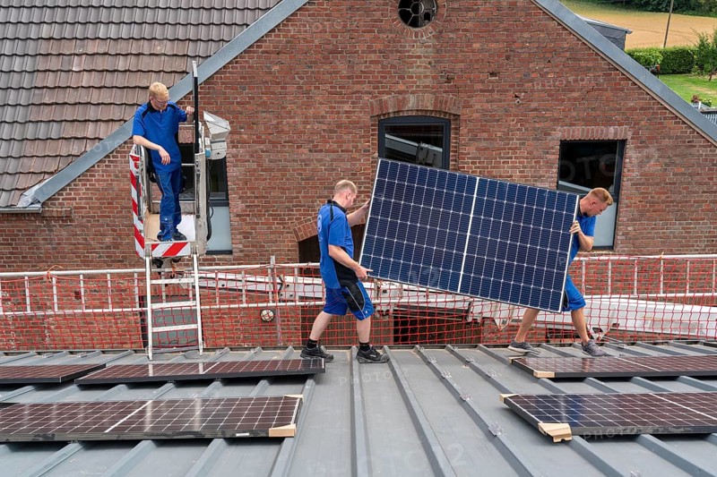 Installation of solar modules on the roof of a barn on a farm, over 240 photovoltaic modules are installed on the roof, North Rhine-Westphalia, Germany, Europe