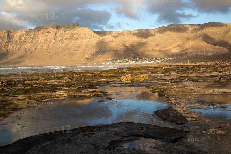 Late afternoon light on beach and cliffs La Caleta de Famara, Lanzarote, Canary islands, Spain, Europe