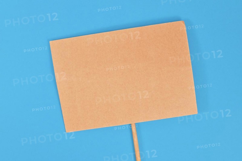Top view of empty cardboard protest sign on blue background