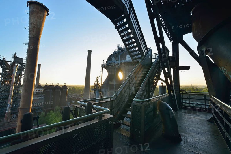 Industrial ruin at sunrise with stairs, metal structures and pipes, flooded with warm sunlight, Landschaftspark Duisburg Nord, Meiderich Hütte, Duisburg, Ruhr area, North Rhine-Westphalia, Germany, Europe