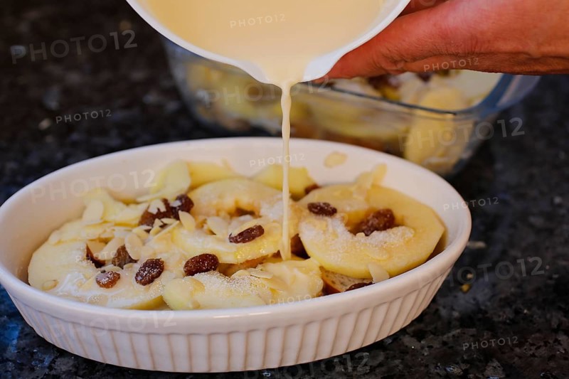 Swabian cuisine, preparation of Ofenschlupfer, sweet main dish or dessert, dessert, typical Swabian, classic, from the oven, casserole, leftovers, rolls with sultanas, apples with milk mixture, casserole dish, gratinated, home cooking, traditional cuisine, food photography, studio, Germany, Europe