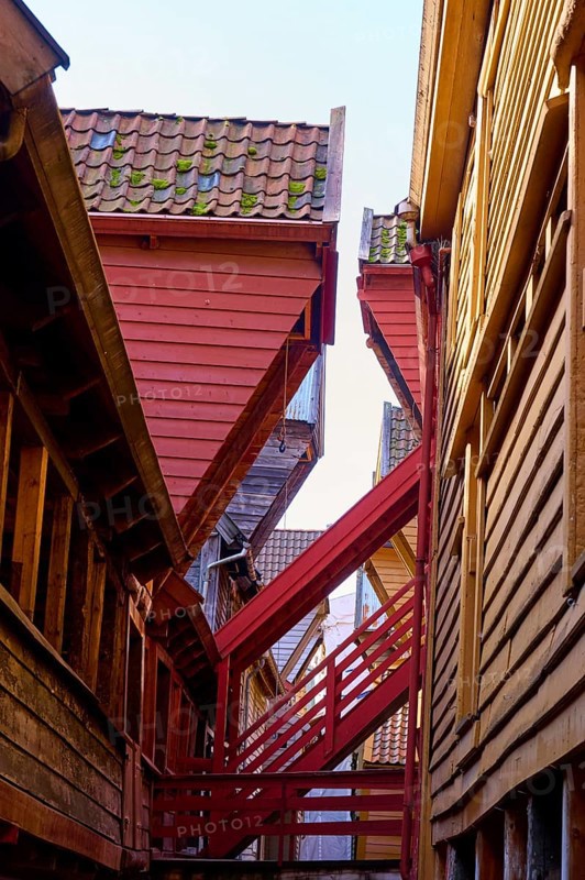 Narrow alley between old half-timbered houses with stairs, dominating wooden architecture in red and brown tones, Historic warehouses, Bryggen, Bergen, Vestland, Norway, Europe