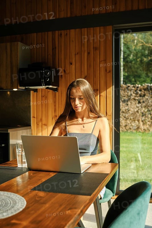 Woman looking for a recipe in internet sitting at the kitchen table