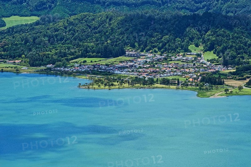 View of the picturesque small town of Sete Cidades on the blue crater lake Lagoa Azul embedded in a green landscape, Lagoa Azul, circular hiking trail, Caldeira das Sete Cidades, Sete Cidades, Sao Miguel Island, Azores, Portugal, Europe