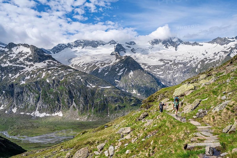 Mountaineer on hiking trail in picturesque mountain landscape, mountain peak with snow and glacier Hornkees and Waxeggkees, summit Hornspitzen and Großer Möseler, Berliner Höhenweg, Zillertal Alps, Tyrol, Austria, Europe