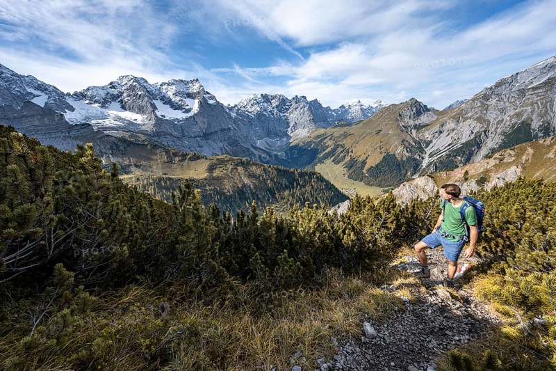 Mountaineers climbing up a hiking trail, mountain panorama with steep rocky peaks, yellow-coloured larches in autumn, view of Laliderspitze, Dreizinkenspitze and Spritzkarspitze peaks, hike to the summit of Hahnkampl, Engtal, Karwendel, Tyrol, Austria, Europe
