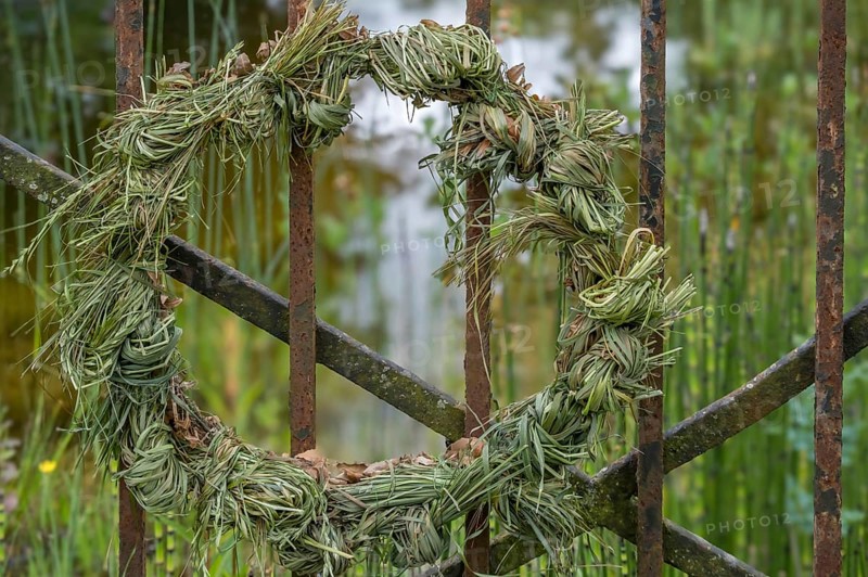 Decorative wreath, door wreath made of grass, hay tied to an iron gate, North Rhine-Westphalia, Germany, Europe