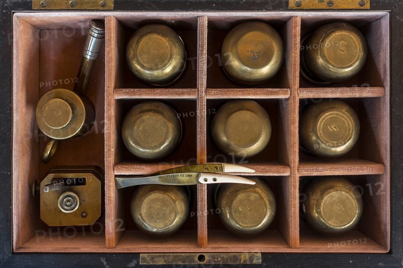 19th century cupping therapy set showing nine brass cups in antique wooden case
